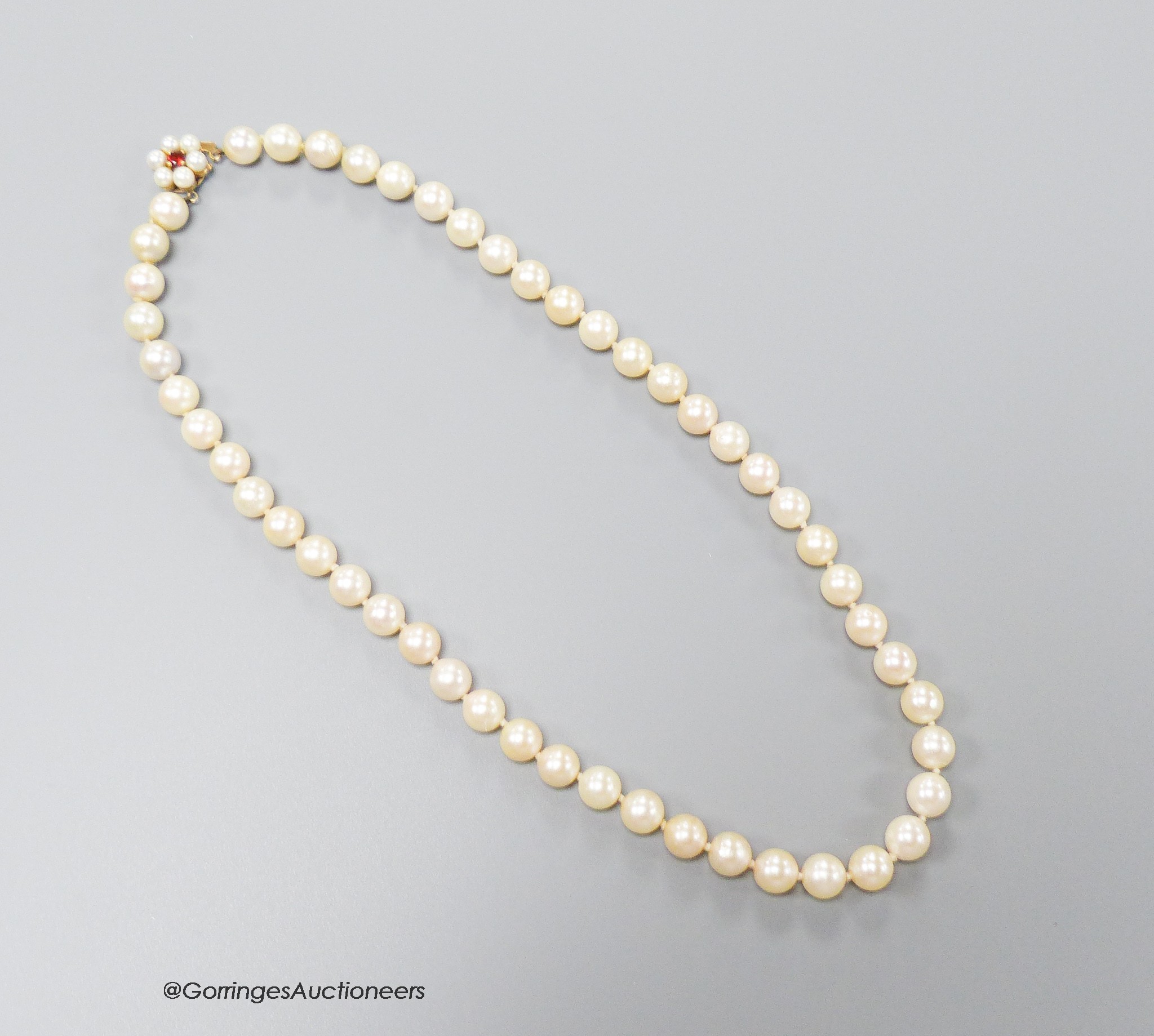 A single strand cultured pearl choker necklace, with garnet? and cultured pearl cluster set yellow metal clasp, 46cm, gross 40.9 grams.